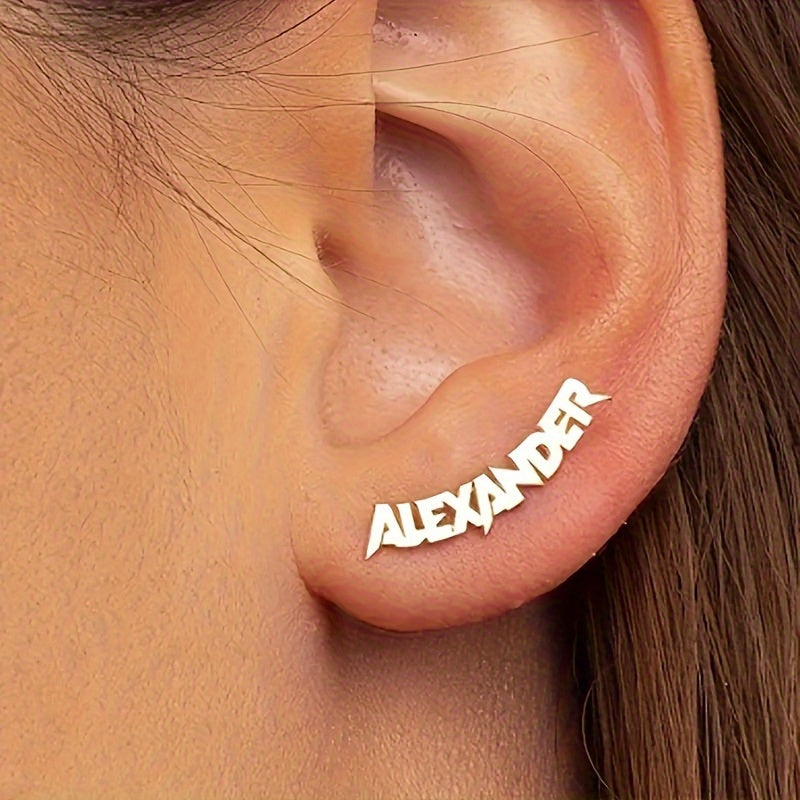 A pair of custom-made name earrings, in gold and silver.